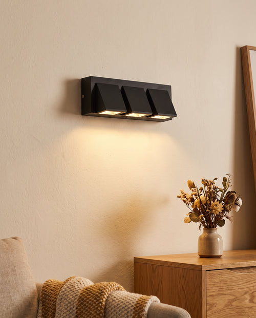 Angled aluminium LED wall light casting a warm downward glow, feature image 1