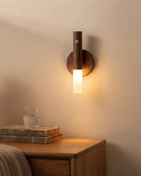 Magnetic walnut wood grain motion sensor night light glowing warm on a bedroom wall